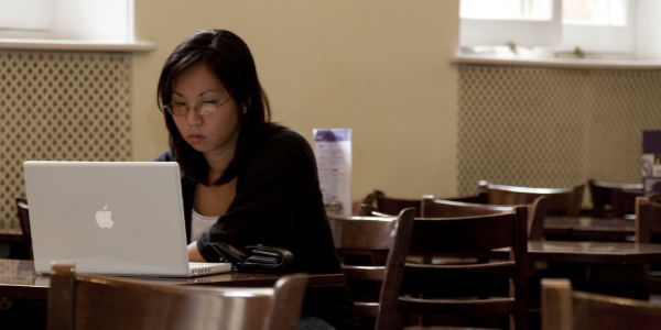 Person looking at a laptop in a cafe